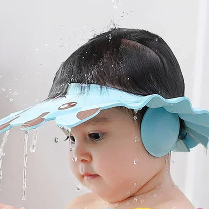 Gyermek kék vízálló fejvédővel fürdés közben, vízcseppekkel a fejen