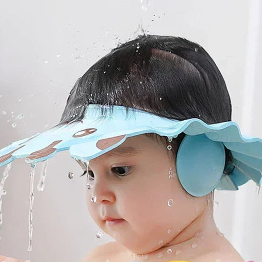 Gyermek kék vízálló fejvédővel fürdés közben, vízcseppekkel a fejen